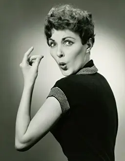 One Mid Adult Woman Only Prints: Woman whistling and snapping fingers in studio, (B&W), portrait
