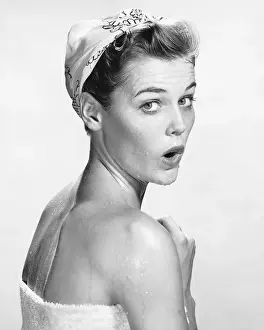 Woman wrapped in towel, looking surprised