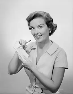 Woman writing list, studio portrait