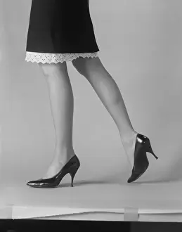 Young Woman Prints: Womans leg with high heels on white background