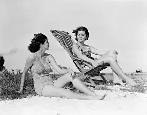 Sunbathing Prints: Two women in bathing suits on windy beach