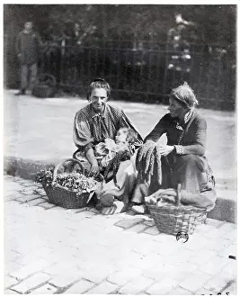 Two Women And Child Sitting On Curb