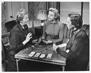 Three women playing cards at home, (B&W)