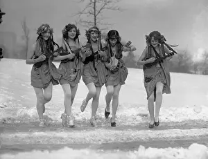 Five women playing ukuleles in snow
