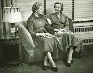 Senior Women Prints: Two women sitting on sofa, talking, indoors, (B&W)