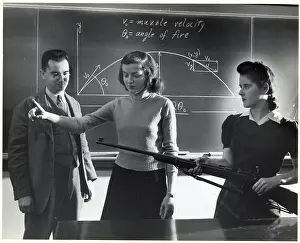 Women Students W/Rifle At Blackboard