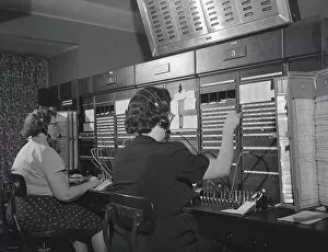 Retrofile Gallery: Two women wearing headsets, working on telephone switchboard. (Photo by H)