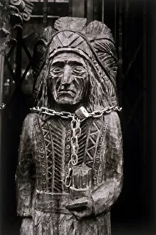 A wooden statue of a Native American