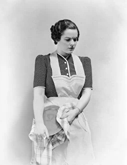 Worried woman in apron, drying dish
