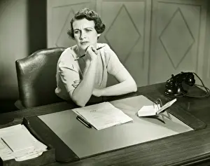 Introspection Prints: Worrying woman sitting at desk in office, (B&W)