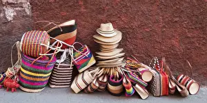 Heap Prints: Woven souvenirs on display on a sidewalk against a wall