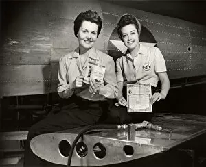WW II aircraft workers holding savings bonds