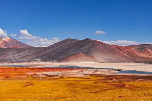 Yellow volcanic scenery with colorful mountains and a blue salt lake