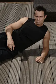 Actions Prints: Young athletic man lying on a terrace