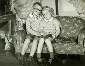 Eyeglasses Prints: Young boy and girl dressed as adults sitting on sofa, portrait