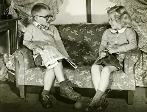 Enjoyment Prints: Young boy and girl sitting on sofa, imitating married couple