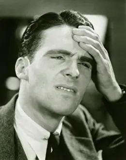 Worried Prints: Young businessman with headache, (B&W), close-up