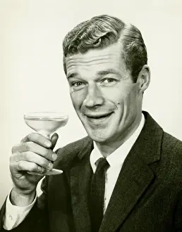 Wavy Hair Prints: Young businessman holding wine glass, (B&W), portrait