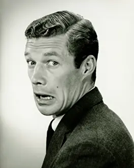 Worried Prints: Young businessman looking frightened, posing in studio, (B&W), portrait