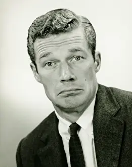 Young businessman looking sad, posing in studio, (B&W), portrait