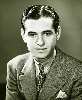Young businessman posing in studio, (B&W), portrait