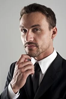 Images Dated 15th August 2012: Young businessman wearing a suit with his hand on his chin, pensive, portrait