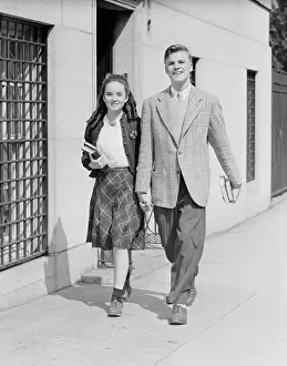 Schoolgirl Prints: Young couple (17-19) walking along sidewalk