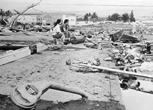 Earthquake Prints: Young Couple Kneeling at Debris of Storm Ridden Settlement