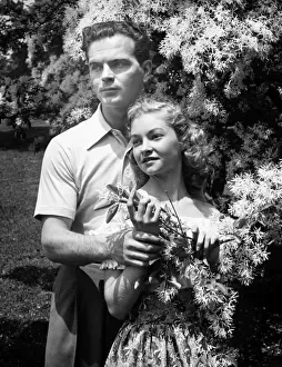 Engagement Prints: Young couple posing at blooming tree in park, (B&W), (Portrait)