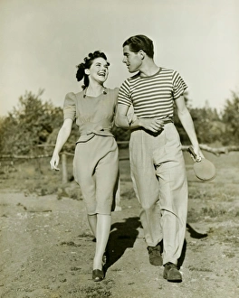 Arm In Arm Gallery: Young couple strolling in field arm in arm, (B&W)