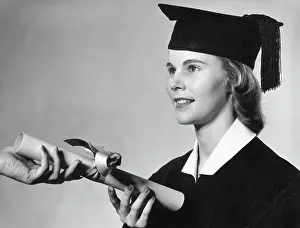 Graduation Prints: Young female graduate receiving diploma with ribbon around it
