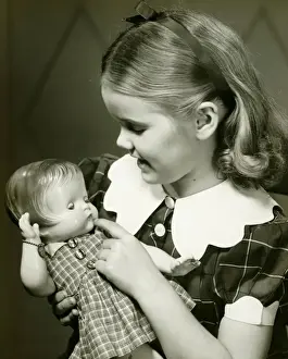 10 11 Years Prints: Young girl (10-11) holding doll, (B&W)