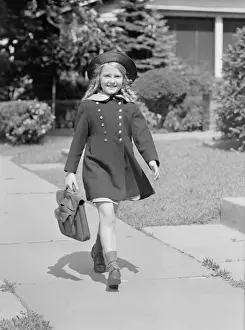 Schoolgirl Prints: Young girl (8-9) with schoolbag on sidewalk, portrait