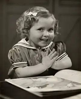 Young girl with book praying