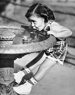 Images Dated 11th November 2015: Young girl drinking from water fountain