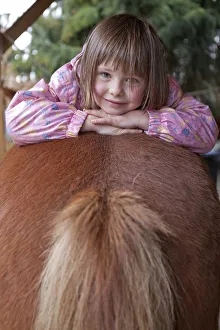 Perissodactyla Gallery: Young girl lying on a pony