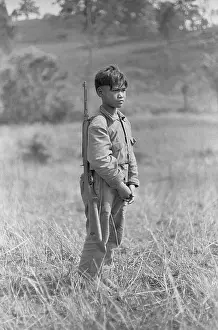 Grassland Prints: Young Laotian Boy in Field with Rifle