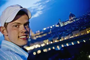 A Young Man With The Cityscape Of Florence In The Background At Dusk