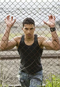 Images Dated 6th October 2012: Young man holding onto a fence