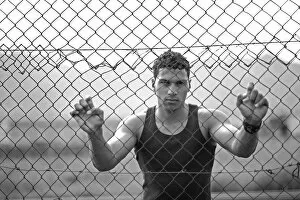 Captivity Collection: Young man holding onto a fence