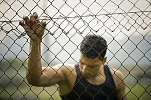 Images Dated 6th October 2012: Young man holding onto a fence