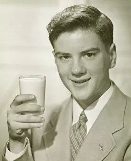 Images Dated 5th May 2006: Young man holding glass of milk, (B&W), portrait