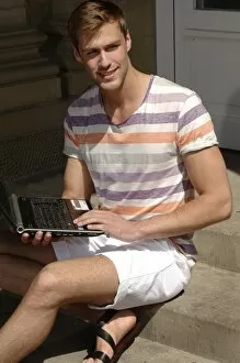 Light Gallery: Young man with laptop sitting on steps