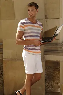 Electronic Prints: Young man with laptop standing in front of a wall