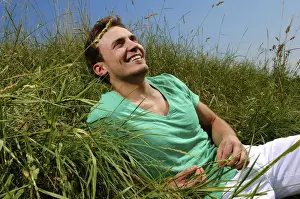 Pause Prints: Young man lying in tall grass, smiling, sunbathing