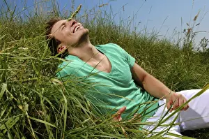 Pause Prints: Young man lying in tall grass, smiling, sunbathing