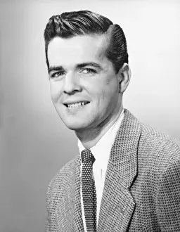 Young man smiling, (B&W), portrait