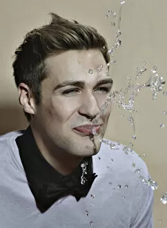 Young man spitting out water