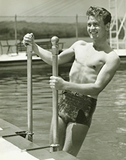 Railing Collection: Young man standing on pool ladder, (B&W)