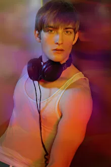 Compact Disc Gallery: Young man in underwear with headphones in colorful lightYoung man in underwear with headphones in